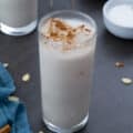 Horchata is in two glasses with few ingredients in cups and a blue towel around.