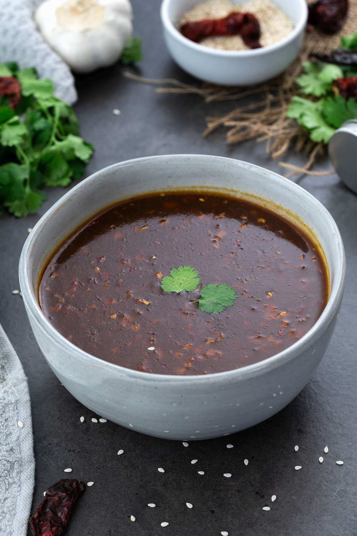 Orange Sauce in a white bowl with few ingredients around.