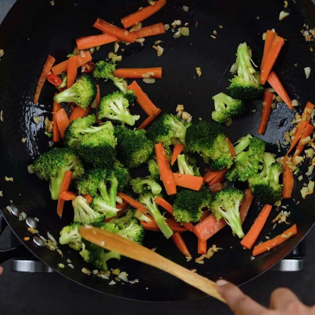Stir frying broccoli and carrots.