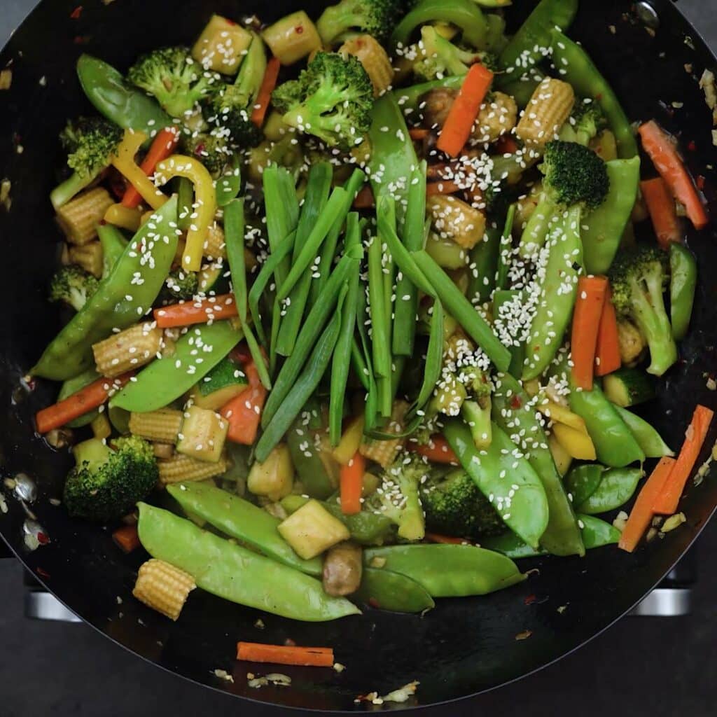 Vegetables garnished with spring onions and white sesame seeds.