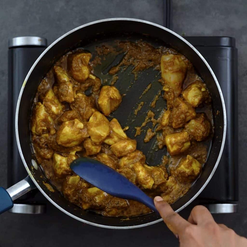 Sauteing chicken in yellow curry paste
