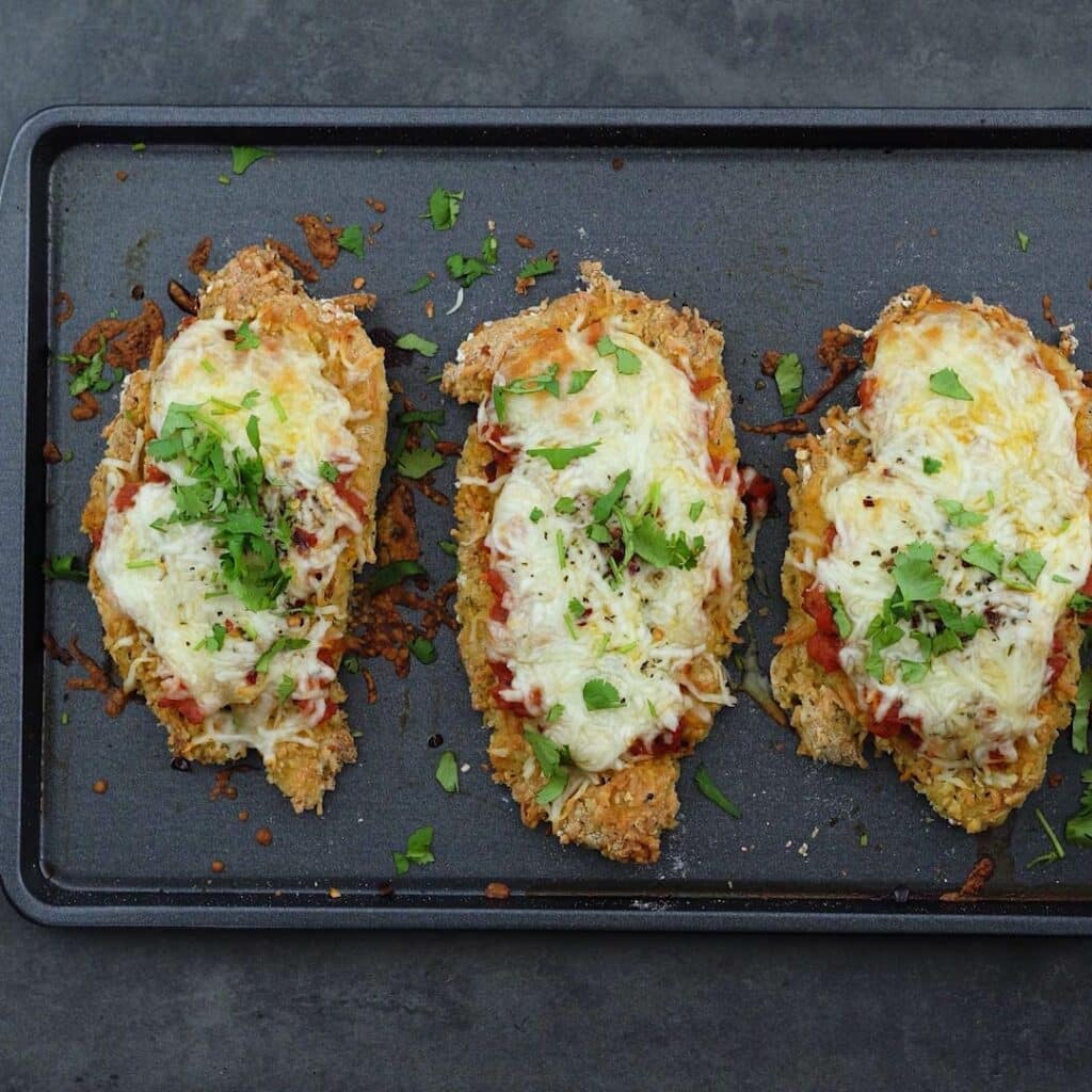 Baked Chicken parmesan placed on a baking tray.