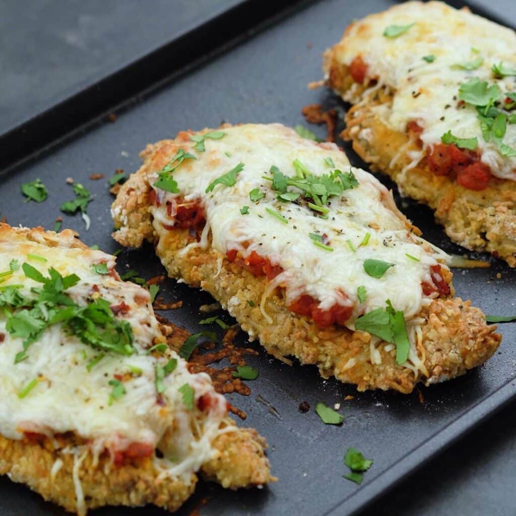 Baked Chicken Parmesan served on a baking tray.