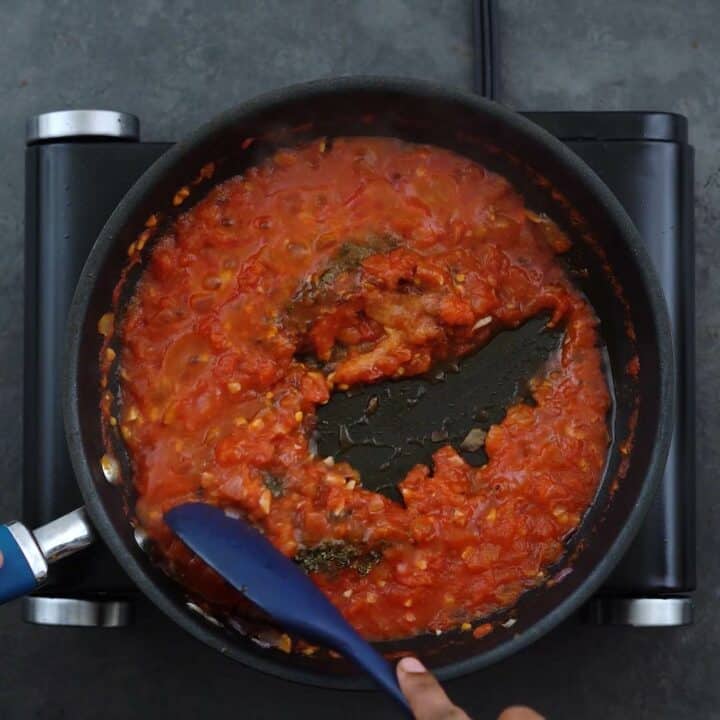 Seasoning the tomato mixture.