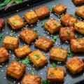 Baked tofu pieces in a baking tray.