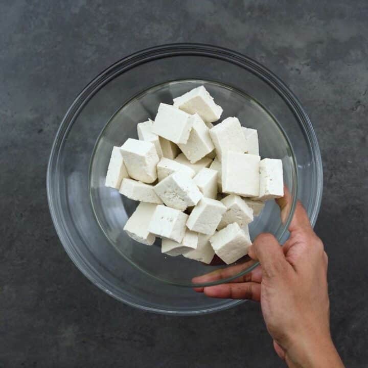 Drained, pressed and cubed tofu in a bowl.