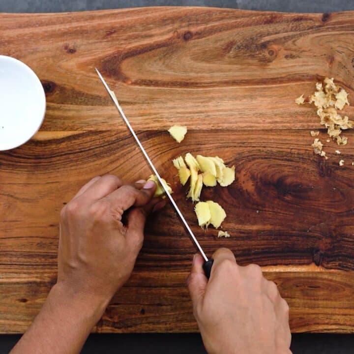 Chopping ginger into small pieces.