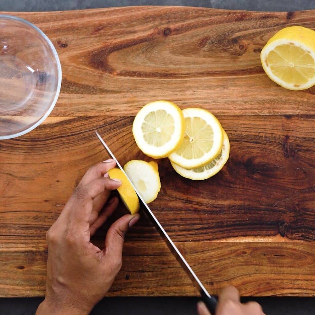 Slicing lemon into circular pieces.