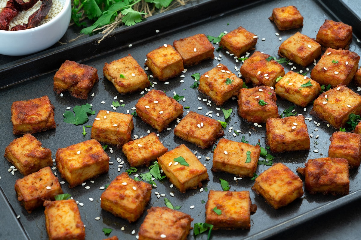 Baked tofu pieces in a baking tray.