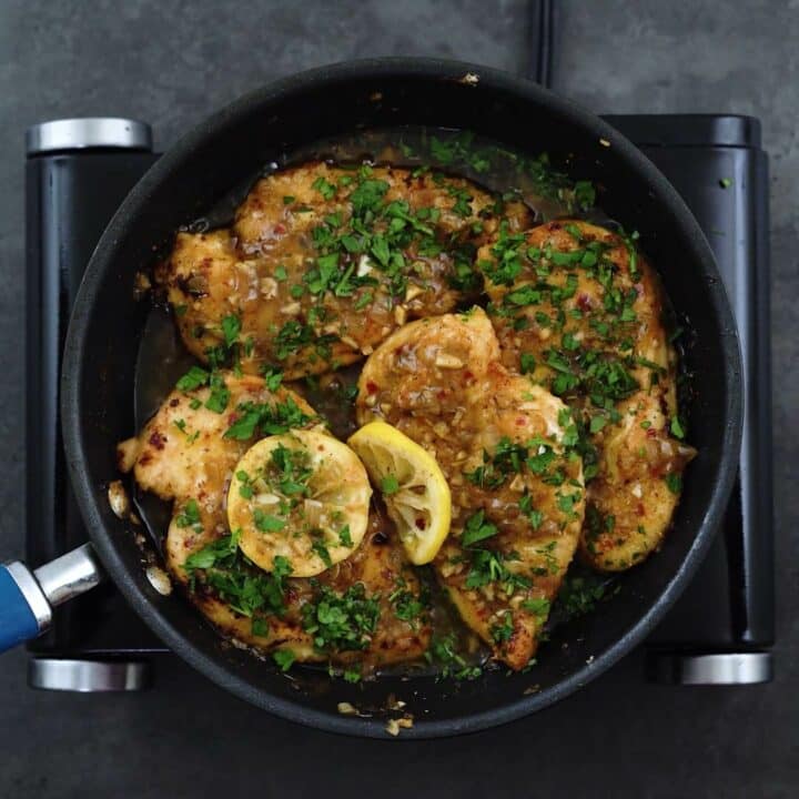 Lemon chicken garnished with parsley leaves.
