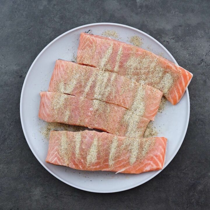 Salmon fillets with season powder on a plate.