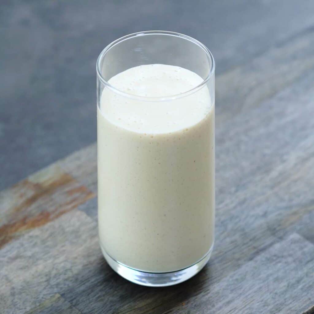 Peach smoothie served in a tall glass.