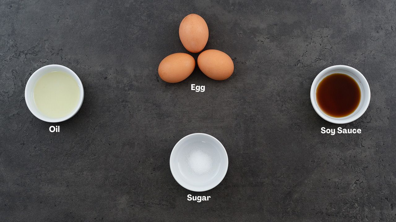 Tamagoyaki (Japanese rolled omelette) recipe ingredients placed on a grey table.