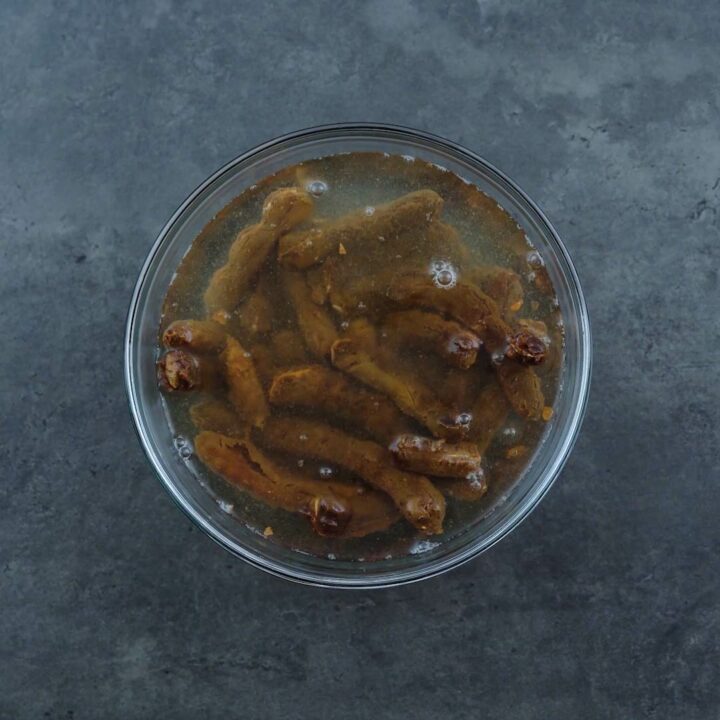 Tamarind pulp soaked in water in a glass bowl.