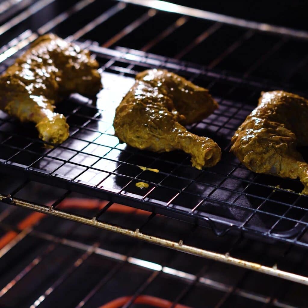 Chicken is grilling inside an oven.