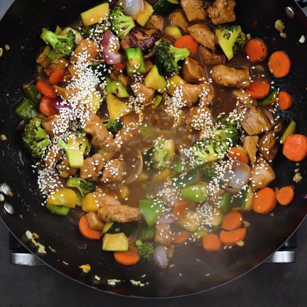 Stir fried chicken and vegetables garnished with sesame seeds.