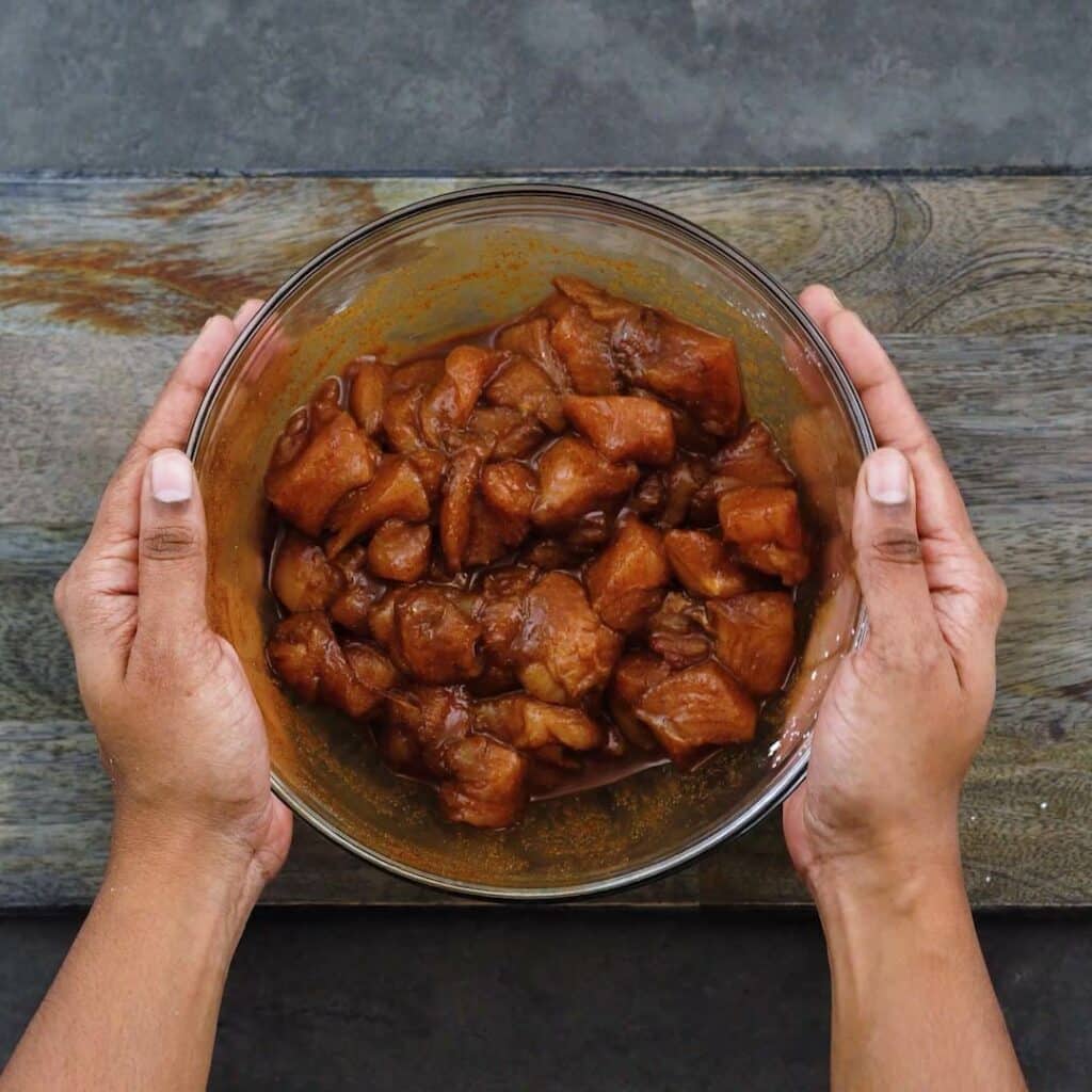 Marinated chicken in a glass bowl.