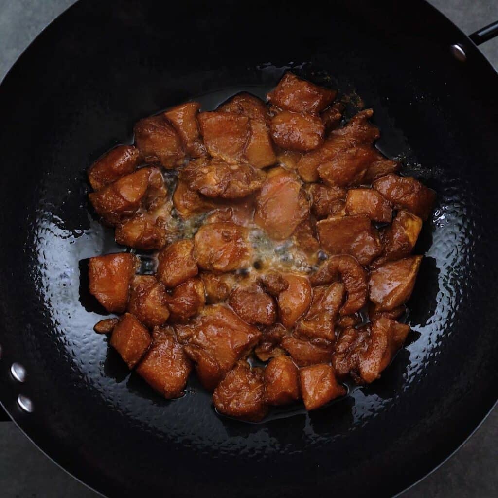 Marinated chicken breast cooking in a wok.