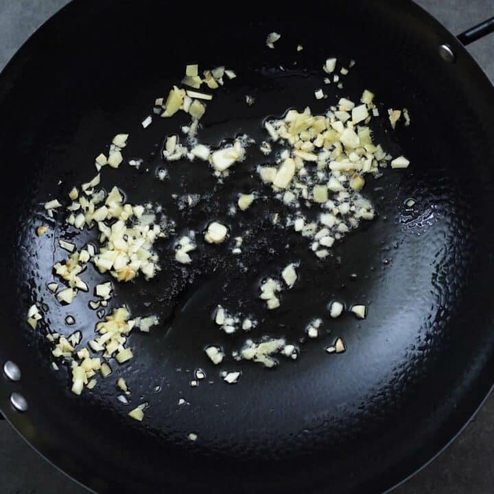 Sauteing aromatics in a wok.