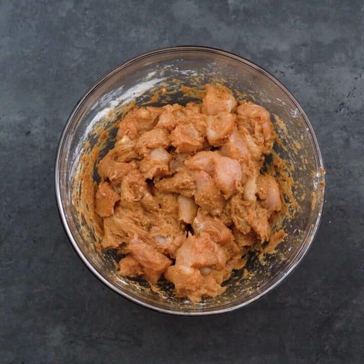 Marinated chicken breast pieces in a bowl.