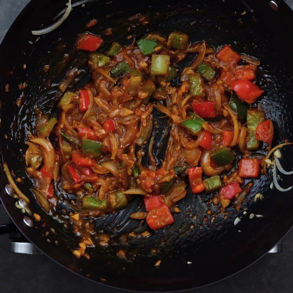 Glossy sauce veggie mixture in a wok.