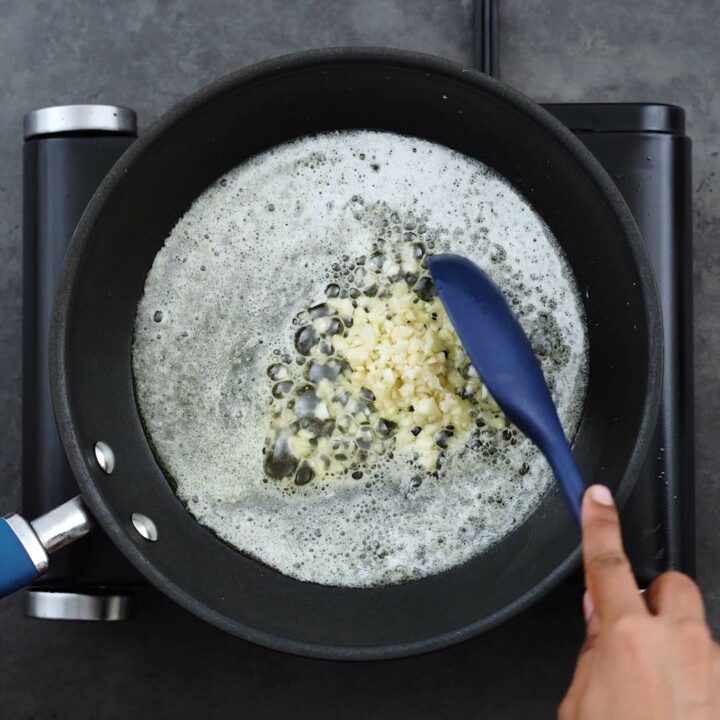 Sauteing garlic in a frying pan.