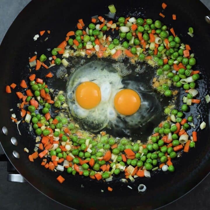 Veggies and eggs in a stir frying wok.
