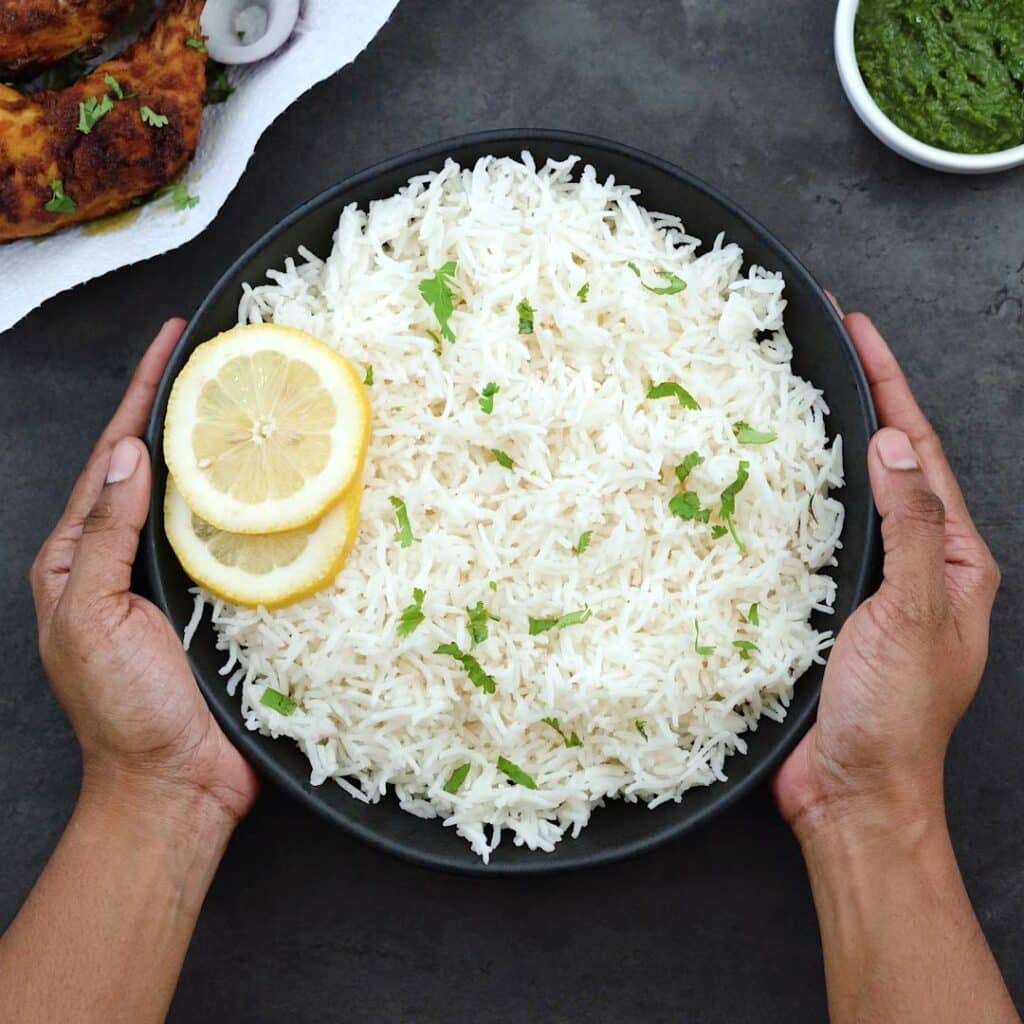 Serving the Basmati Rice in a black bowl with tandoori and green chutney.