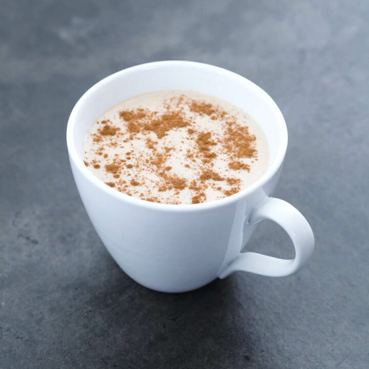 Mexican Atole served in cup with cinnamon powder sprinkled on it.