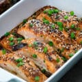 Teriyaki Salmon fillets in a ceramic baking tray with few ingredients around.