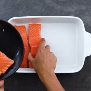 Placing a Salmon fillets in a baking tray.