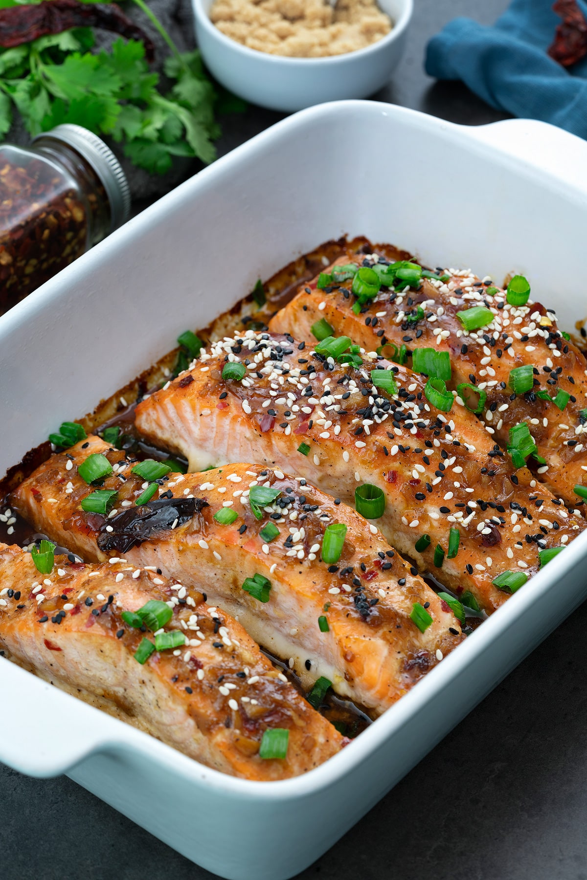 Teriyaki Salmon fillets in a ceramic baking tray with few ingredients around.
