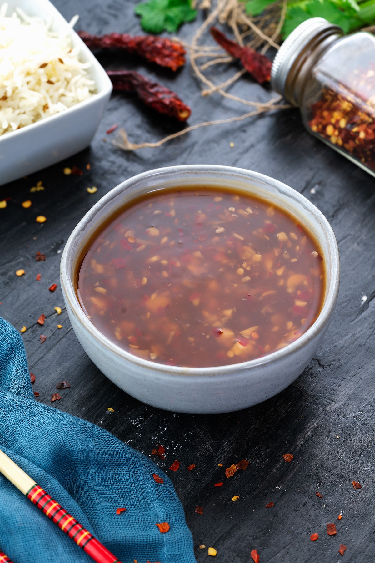 Thai Sweet Chili Sauce in a white bowl with few ingredients around.