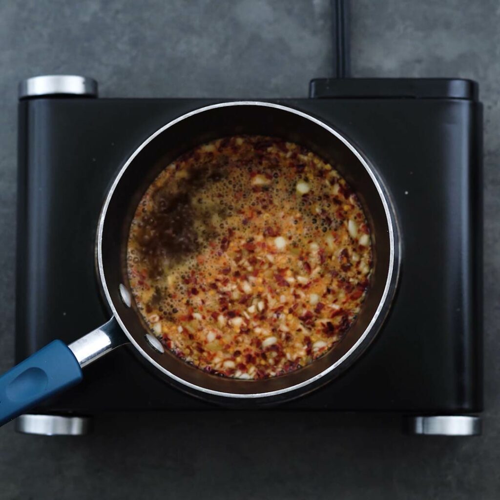 Ginger, garlic, chili and sauce mixture boiling in the saucepan.