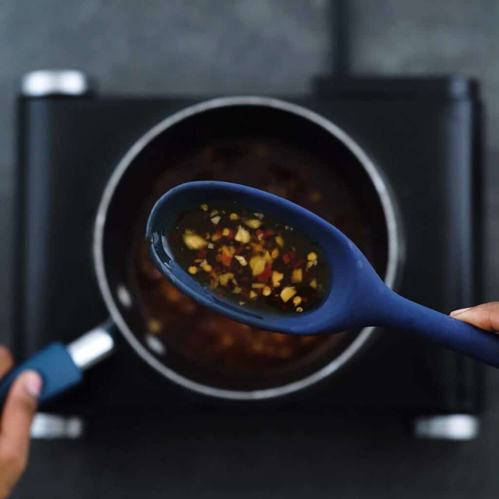 Showing the texture consistency of the Thai Sweet Chili Sauce in blue spoon.