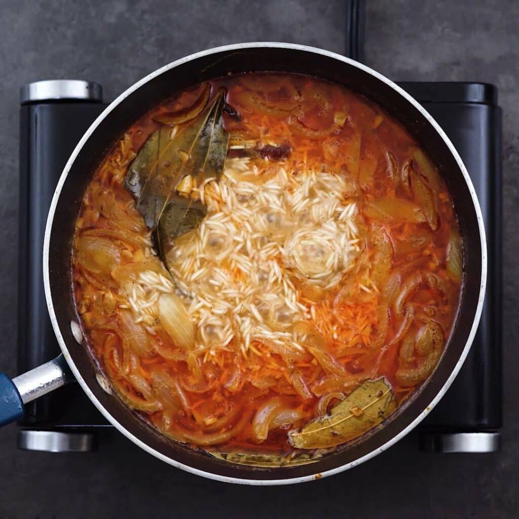 Rice mixture boiling in a pot.
