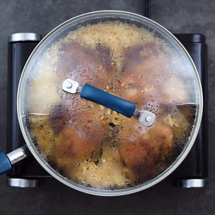 Chicken and rice cooking with pan lid closed.