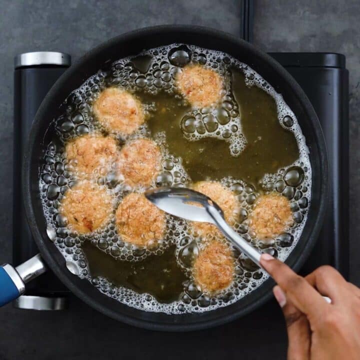 Stirring the chicken to cook evenly.