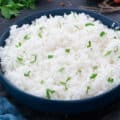 Jasmine Rice in a blue bowl on a grey table.
