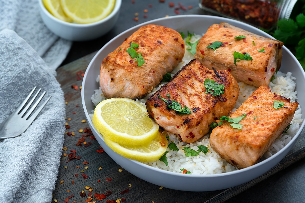 Pan Seared Salmon in a white bowl with few ingredients around.