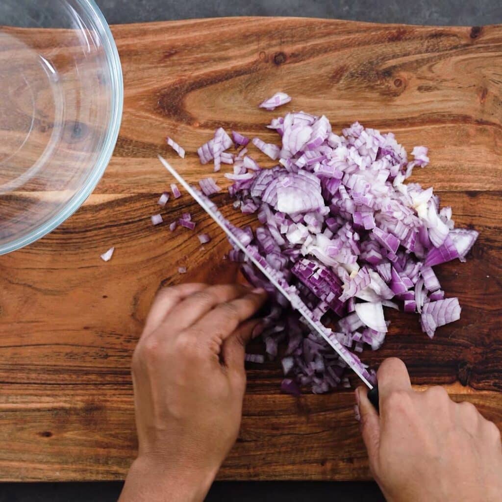 Chopping onions on a cutting board.