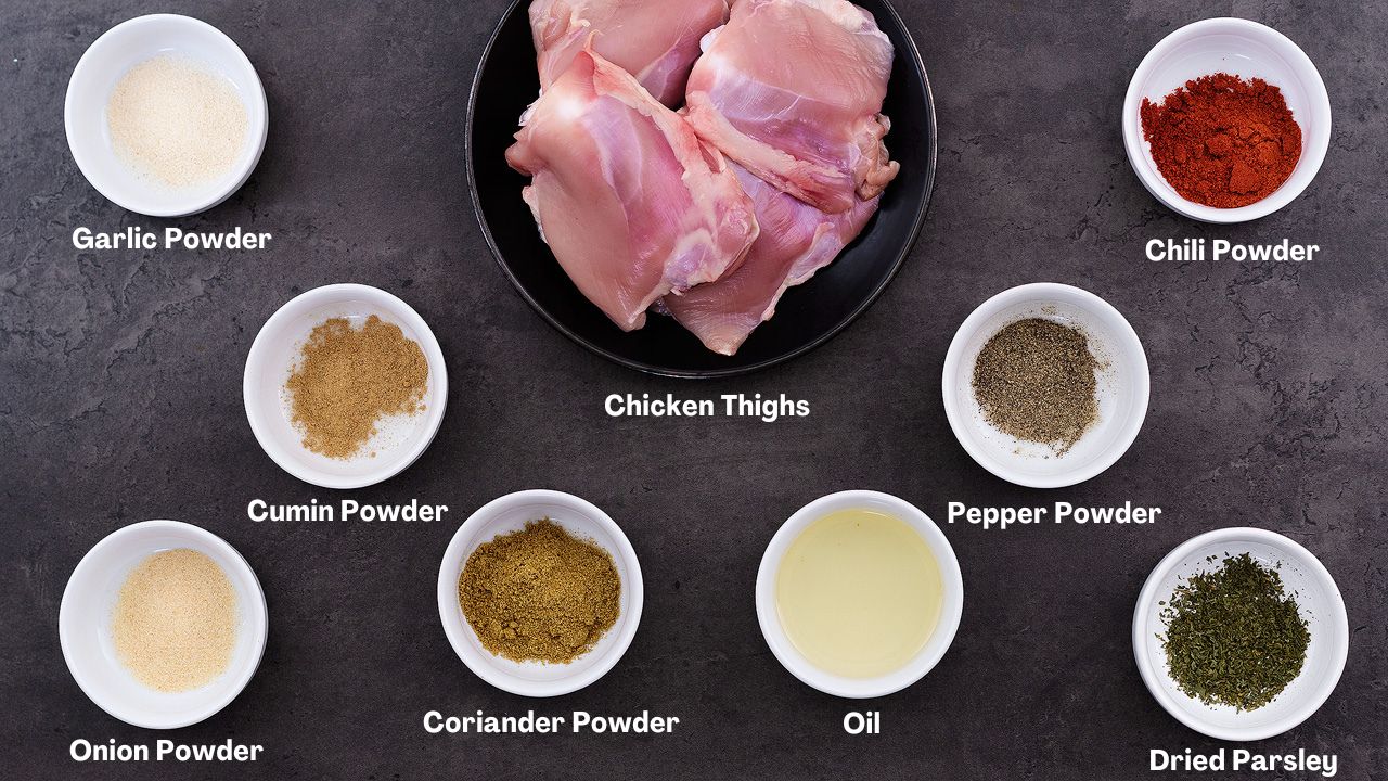 Ingredients for a baked chicken and rice recipe are arranged on a grey table.