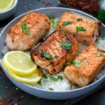 Pan-Seared Salmon Served in a White Bowl with Rice and Lemon Slices