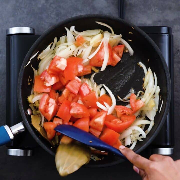 Sauteing tomatoes in a pan.