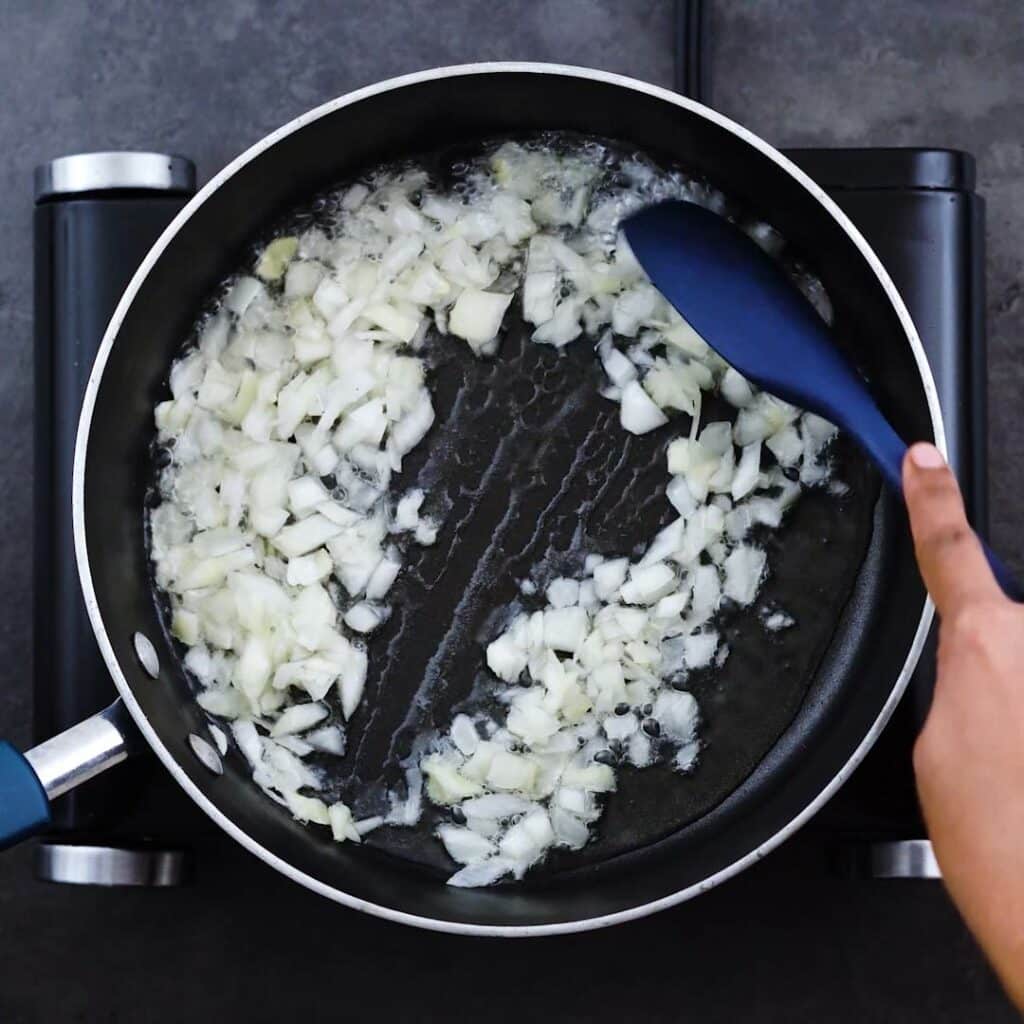 Sauteing onions to soft in a pan.