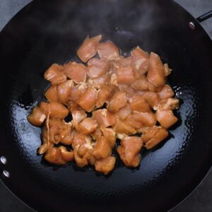 Marinated Chicken frying in a wok.