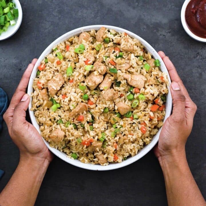 Serving Chicken Fried Rice in a white bowl with ketchup alongside.