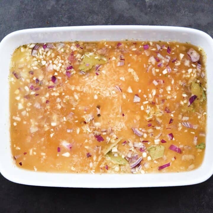 Rice mixture with broth in a baking pan.