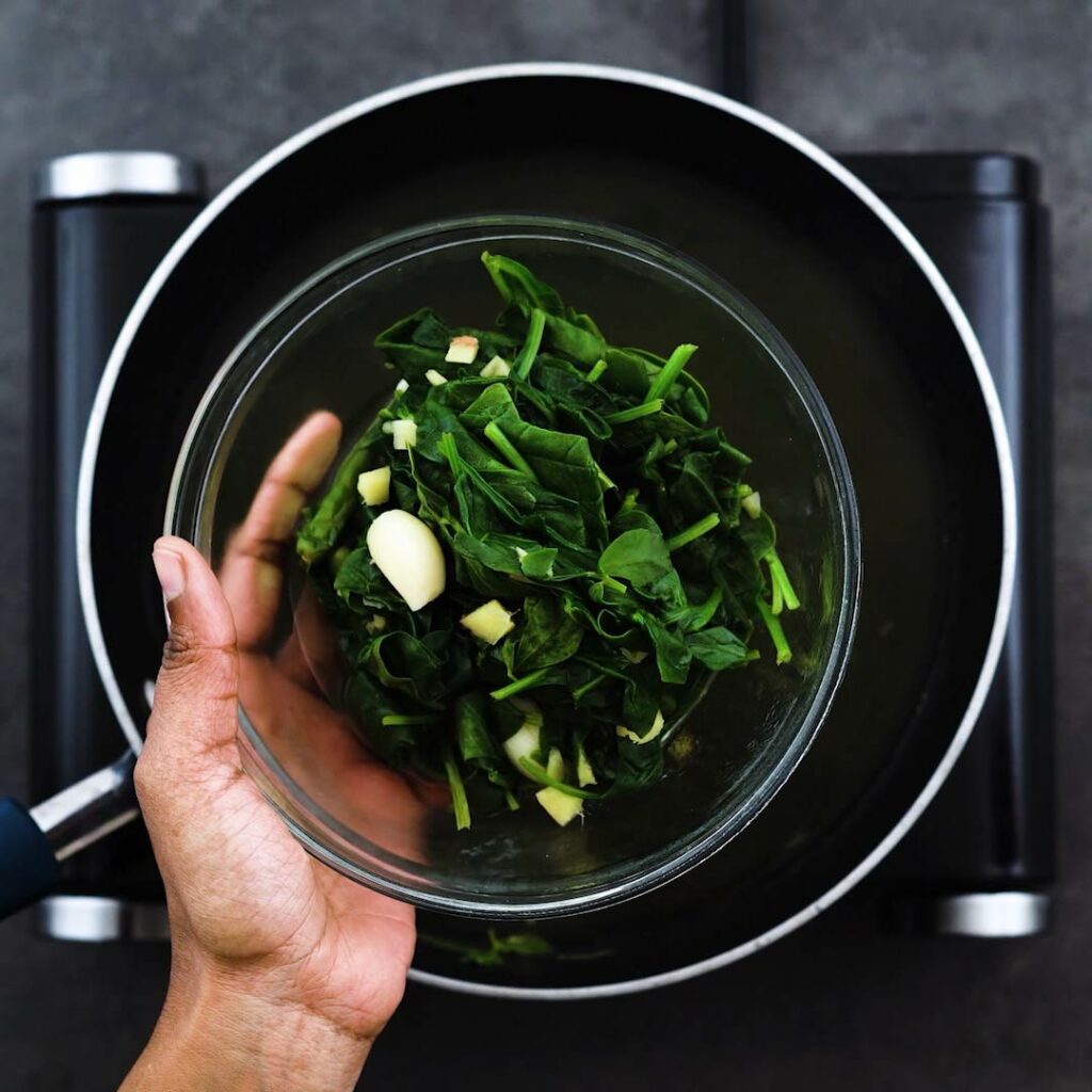 Blanched greens and aromatics in a bowl.
