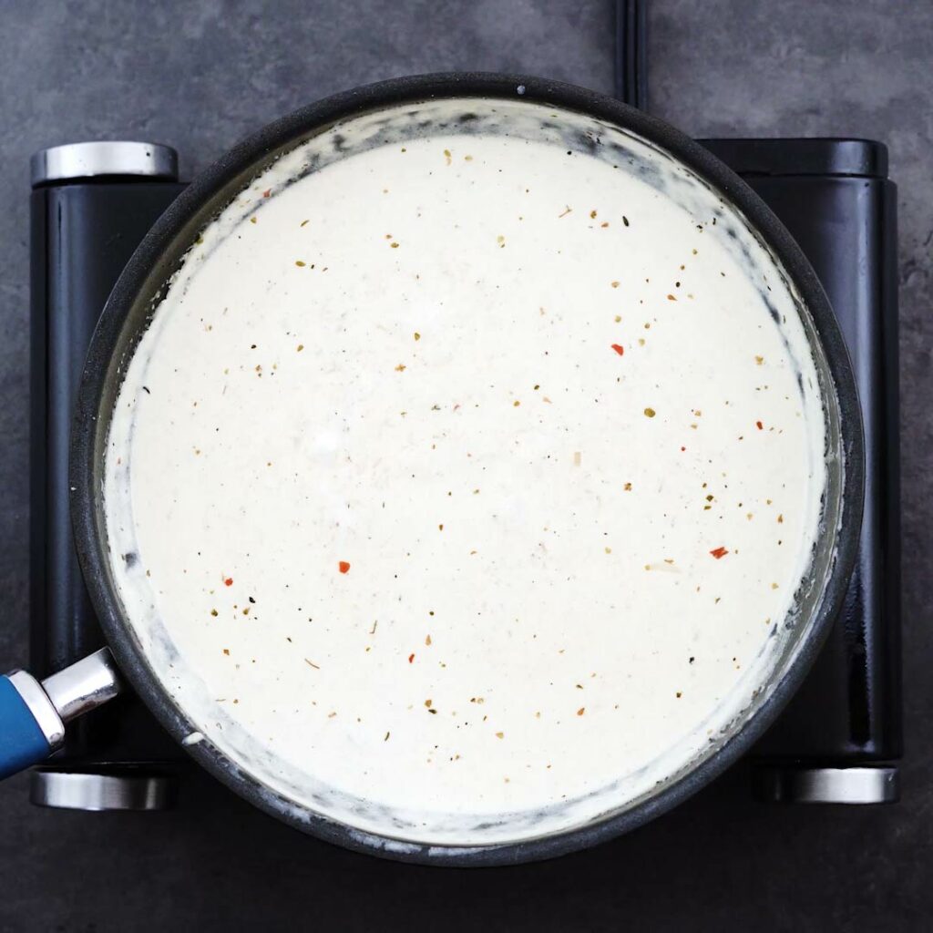 Silky smooth alfredo sauce in a pan.